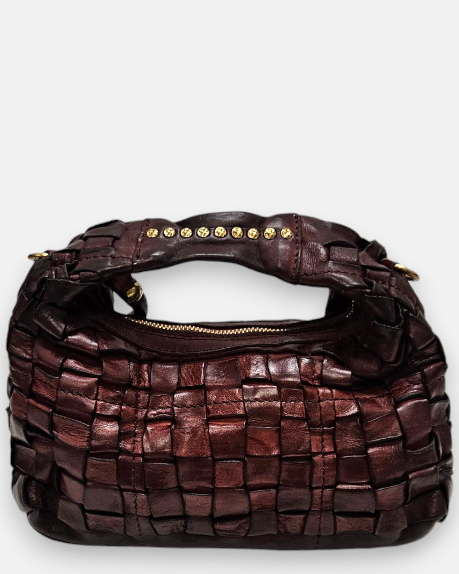 bolso Agnese pequeño de piel elaborada a mano, destacando su textura tridimensional y su asa superior con tachuelas doradas.