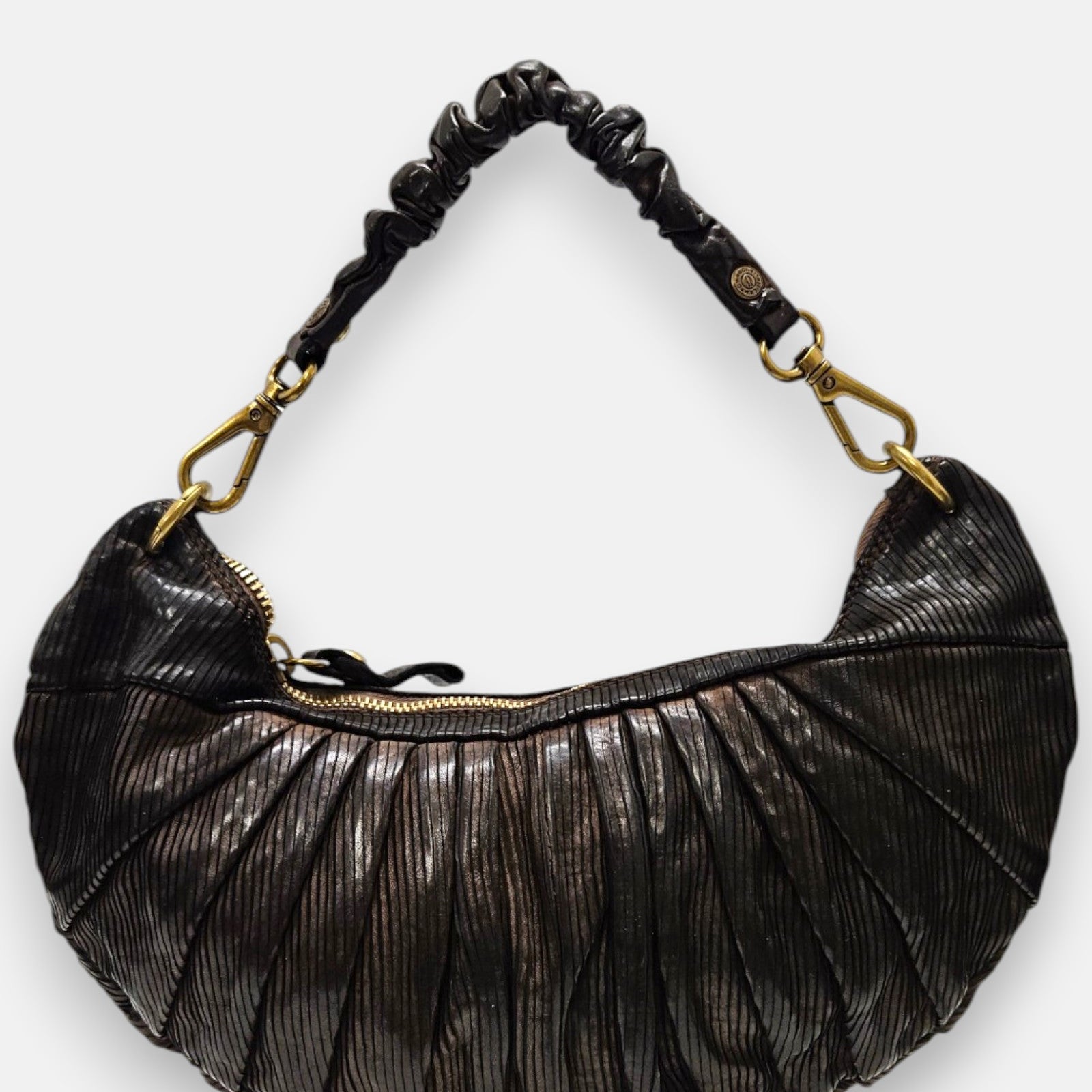 bolso Beatrice de piel marrón con plizado vertical, silueta media luna y asa fruncida con mosquetones dorados.