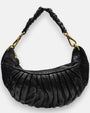 bolso Carlotta de piel negra con plizado vertical, silueta media luna y asa fruncida con mosquetones dorados.