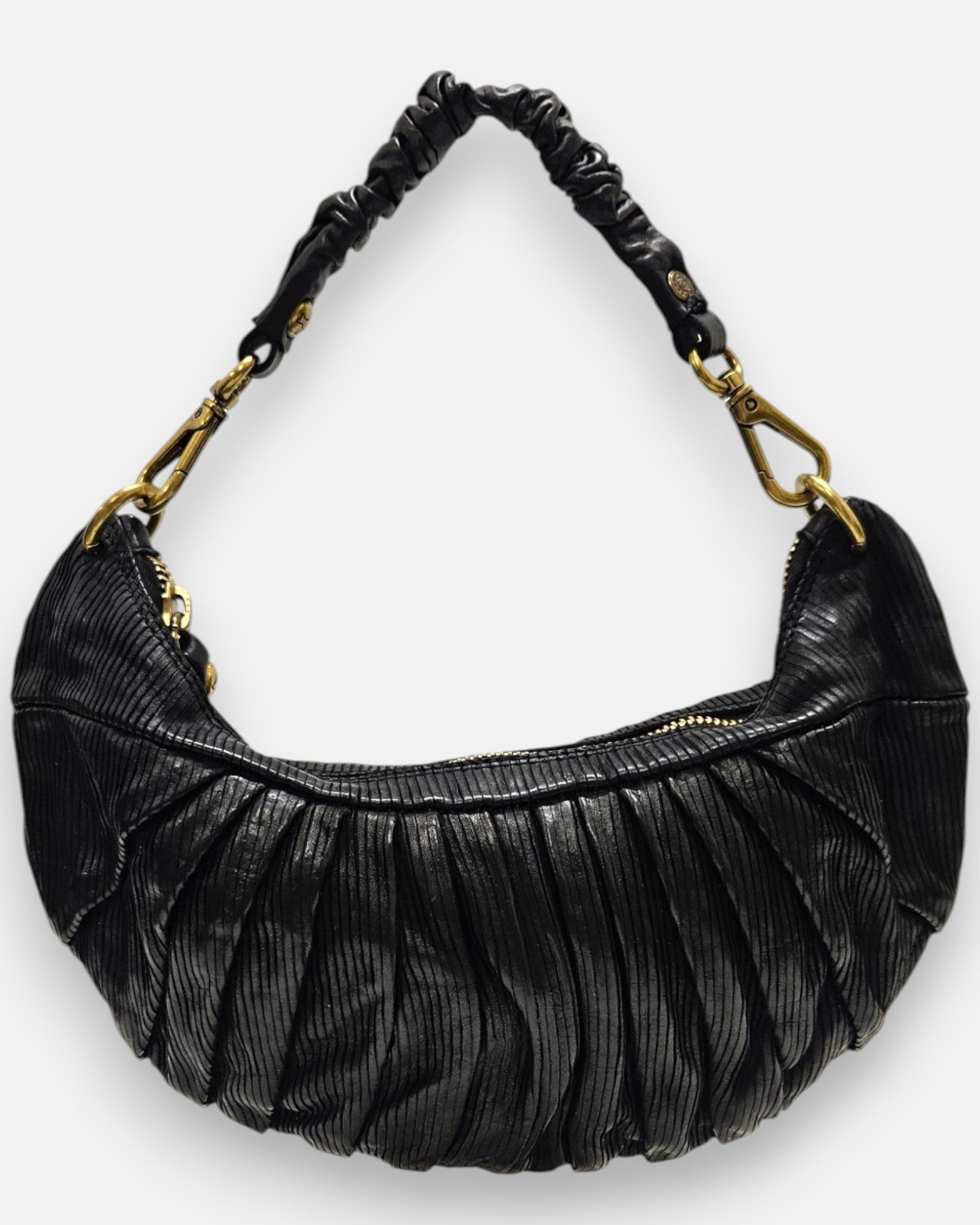bolso Carlotta de piel negra con plizado vertical, silueta media luna y asa fruncida con mosquetones dorados.