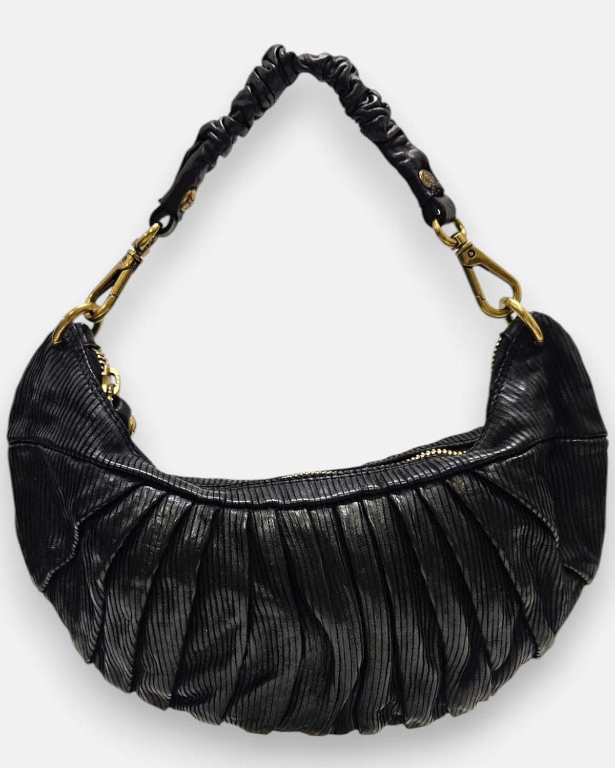 bolso Carlotta de piel negra con plizado vertical, silueta media luna y asa fruncida con mosquetones dorados.