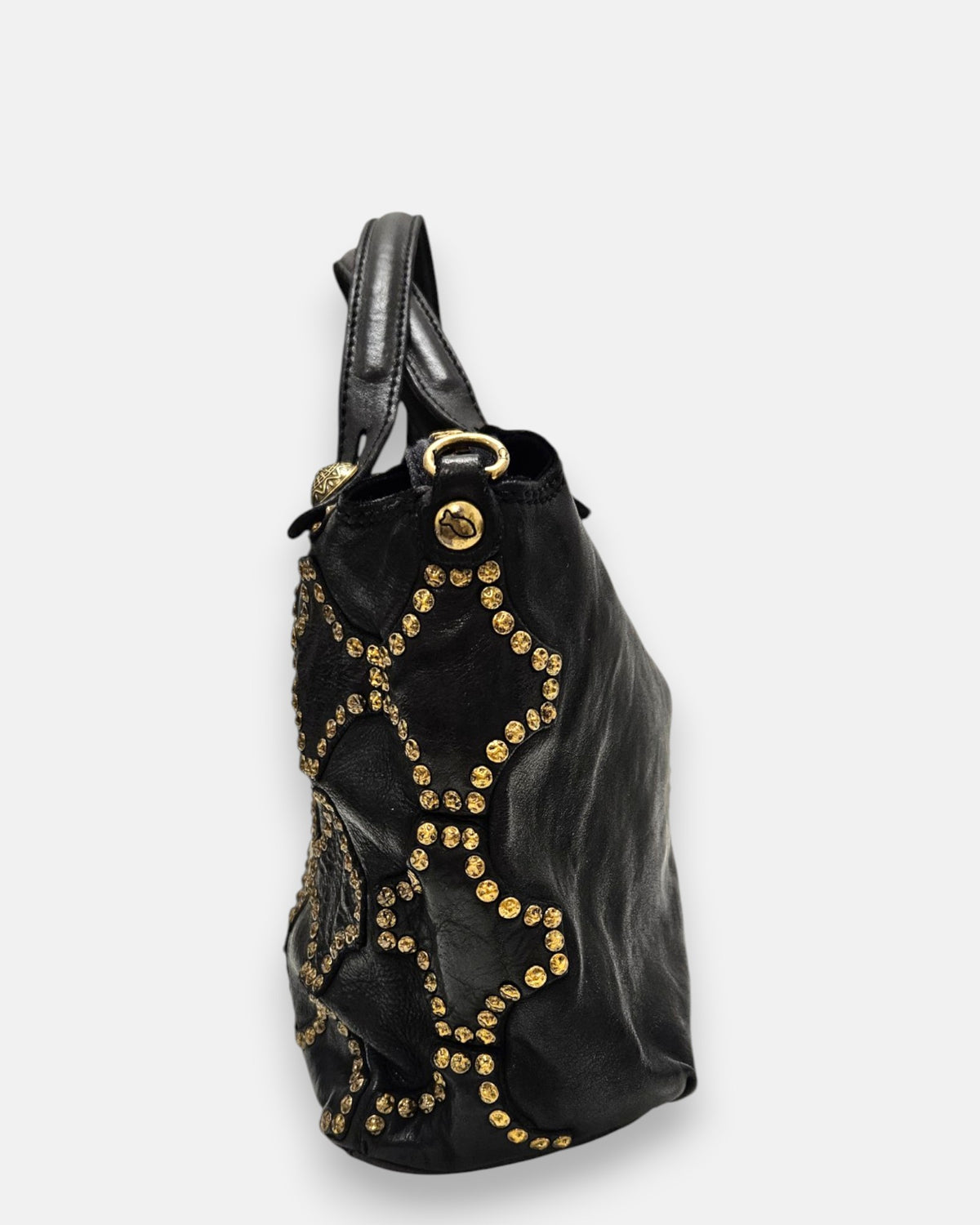 lateral del bolso Luciana, mostrando la profundidad del fuelle de piel flexible, la continuidad del diseño tachonado y el remache con el pez grabado.