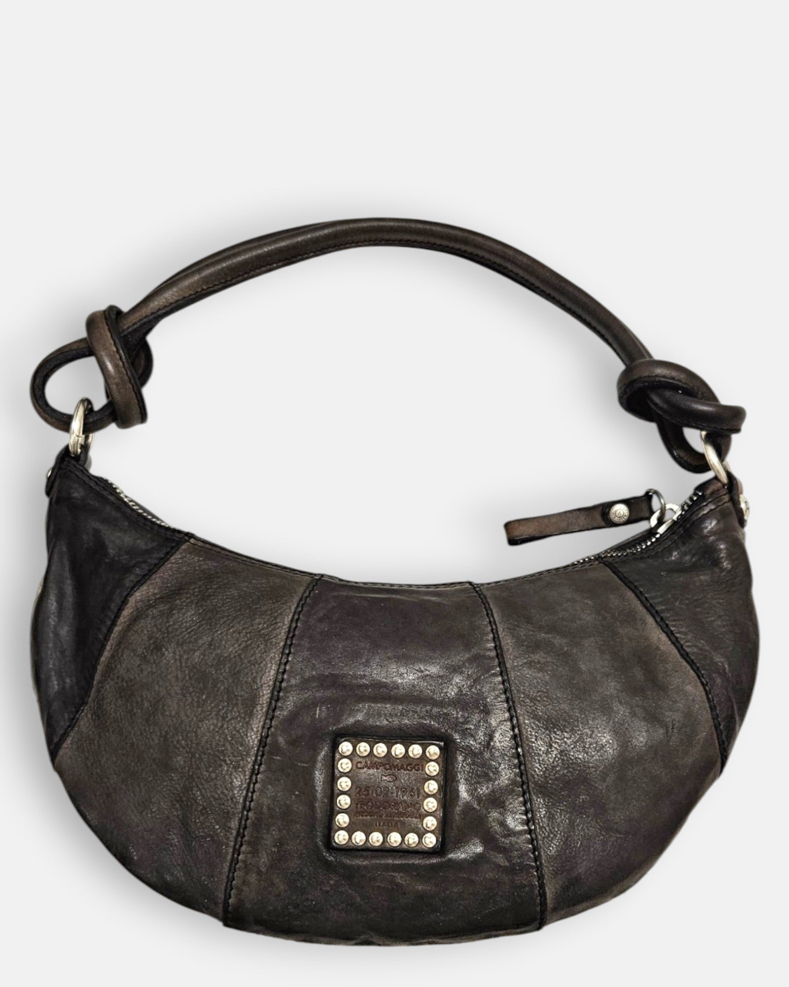 reverso en piel negra lisa del bolso Gaia, detallando en el centro el parche cuadrado de piel con tachuelas plateadas envejecidas.