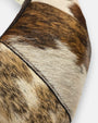 primer plano macro de la textura frontal del bolso Elena, permitiendo apreciar el brillo del pelo corto, las vetas naturales y el minucioso pespunte de la costura.