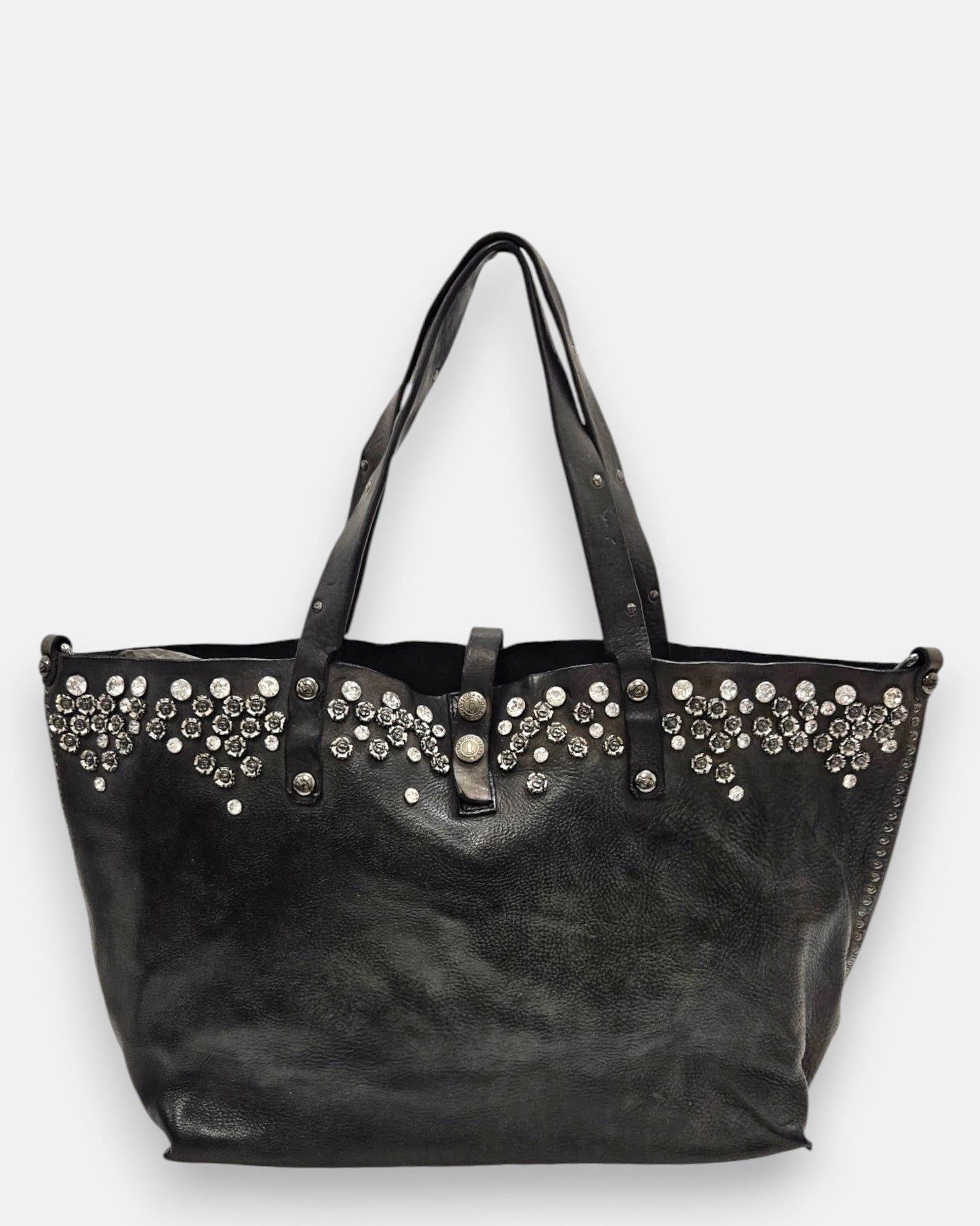 bolso Chiara de piel gris, destacando su franja superior ornamentada con cristales y apliques florales metálicos junto a sus asas dobles.