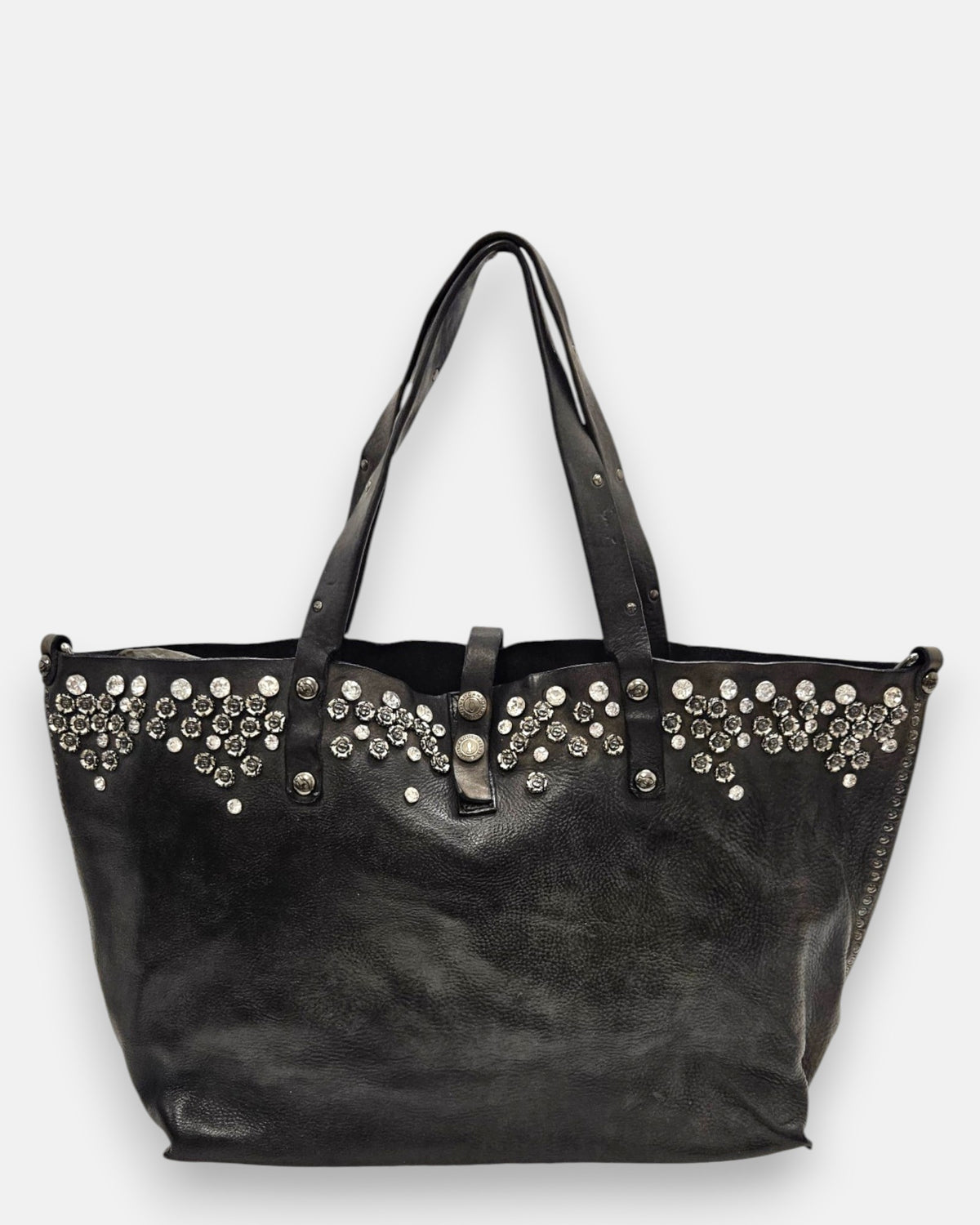 bolso Chiara de piel gris, destacando su franja superior ornamentada con cristales y apliques florales metálicos junto a sus asas dobles.
