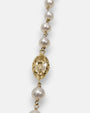 primer plano macro de la pulsera Livia, permitiendo apreciar el cincelado artesanal del engaste chapado en oro, la perla nacarada y el facetado del cristal en talla marquesa.