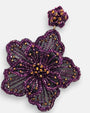 primer plano macro del pendiente Fleur Violette, permitiendo apreciar el trabajo artesanal de bordado sobre tul y los destellos dorados del centro floral.