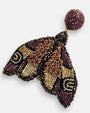 primer plano macro del pendiente Papillon de Nuit Violet et Bronze, permitiendo apreciar el bordado en relieve con canutillos cobrizos y las microcuentas en tonos violeta y oro.