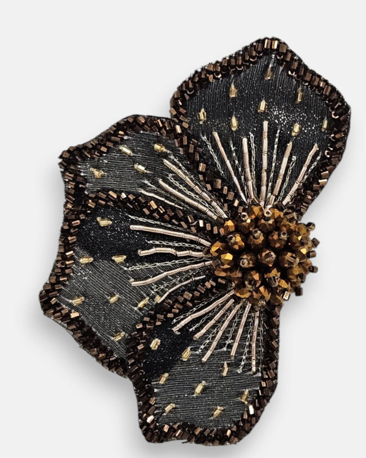 primer plano macro del pendiente Fleur Noire et Bronze, permitiendo apreciar el bordado de microcuentas, los canutillos metalizados y los pistilos tridimensionales.