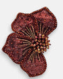 primer plano macro del pendiente Fleur Rouge et Bronze, permitiendo apreciar el tramado de la malla granate, las microcuentas bronce y los pistilos tridimensionales.