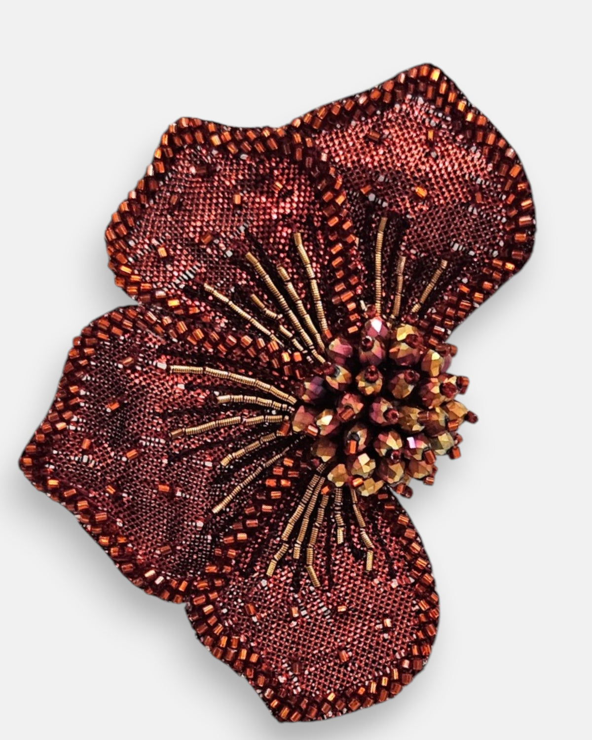 primer plano macro del pendiente Fleur Rouge et Bronze, permitiendo apreciar el tramado de la malla granate, las microcuentas bronce y los pistilos tridimensionales.