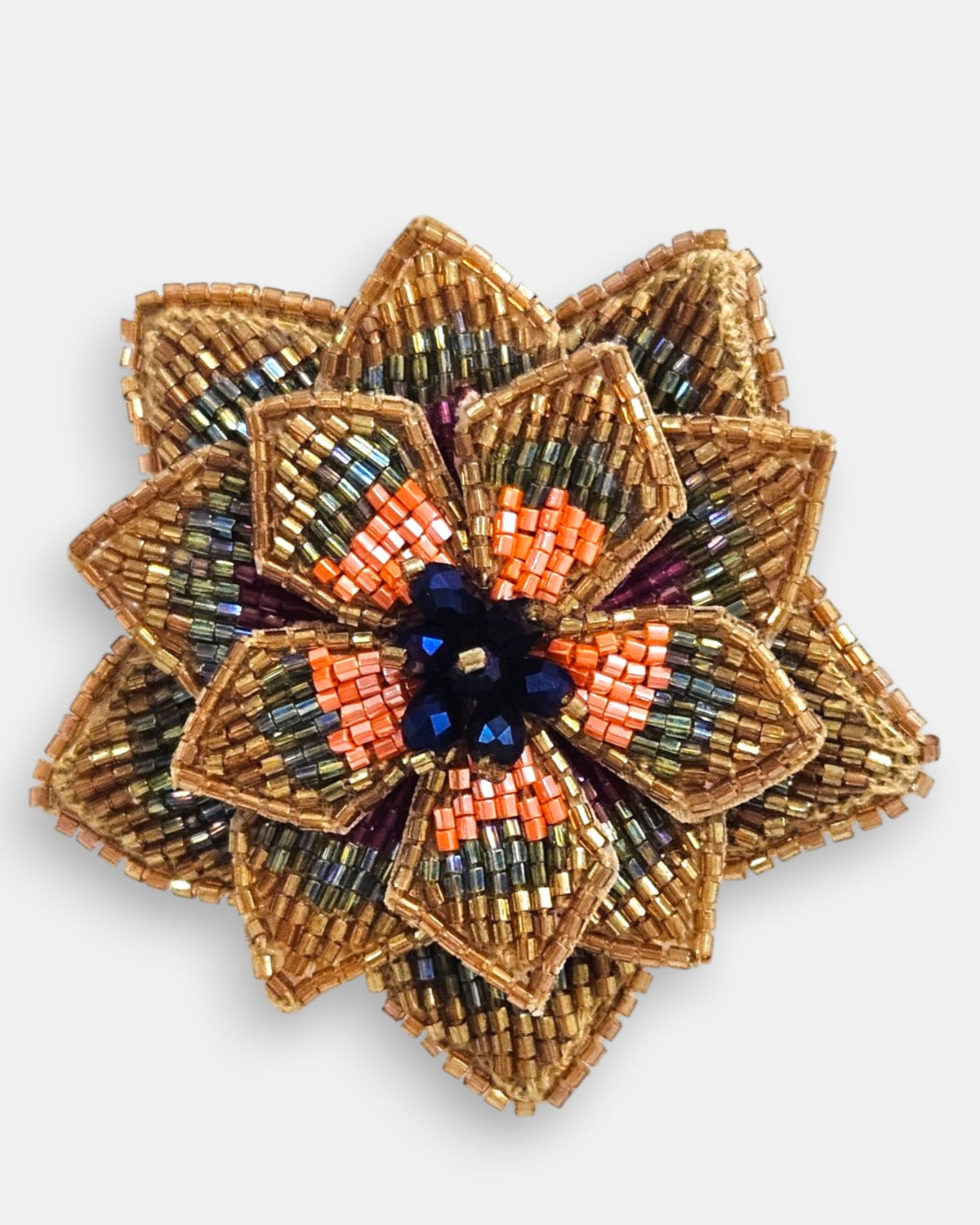 primer plano macro del pendiente Fleur de Lotus Bronze, permitiendo apreciar el trabajo artesanal de las microcuentas bronce y oro con el centro de cristales negros.