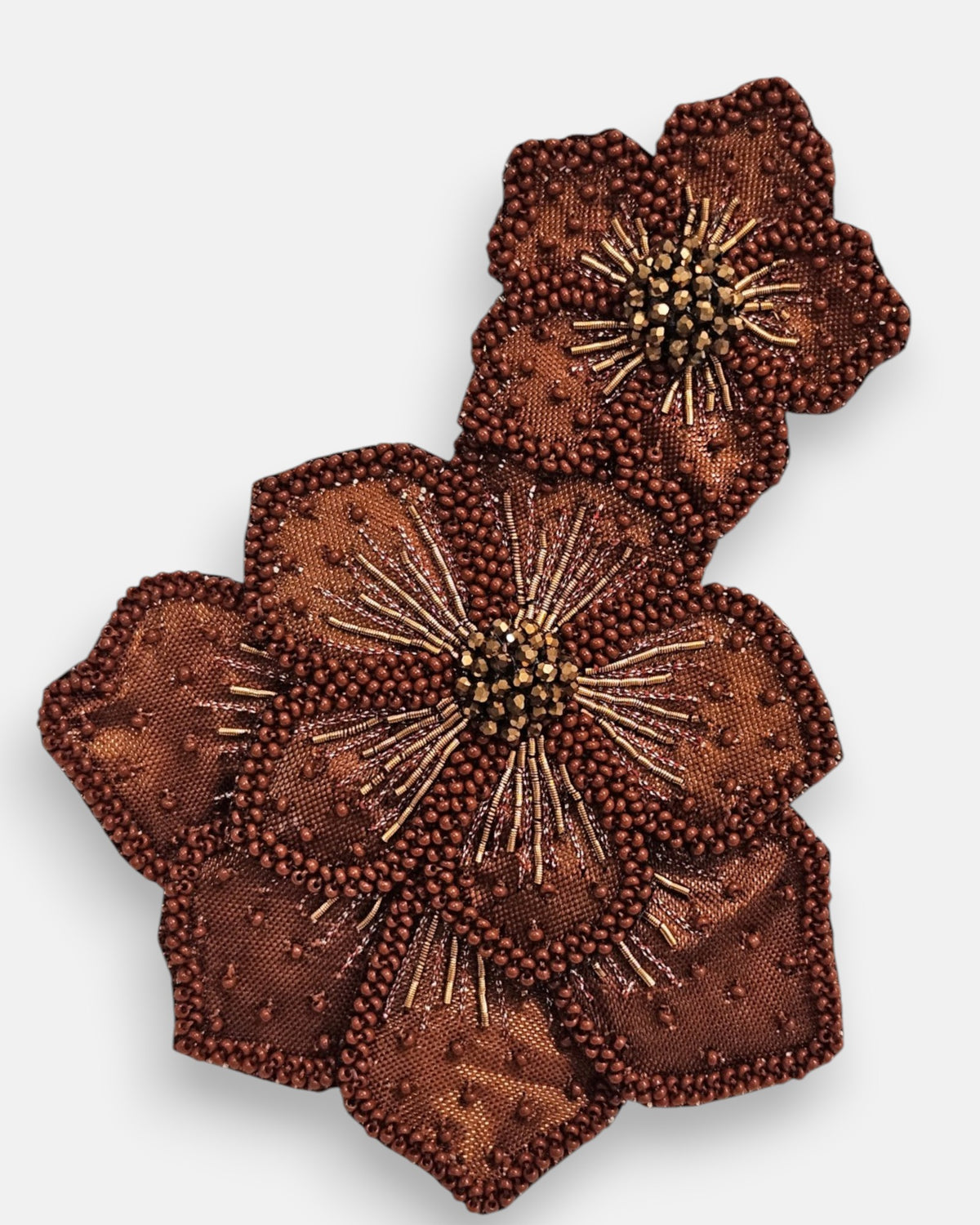 primer plano macro del pendiente Fleur Double Marron et Bronze, permitiendo apreciar el perfilado de microcuentas, los canutillos dorados y el centro de cristales faceteados.