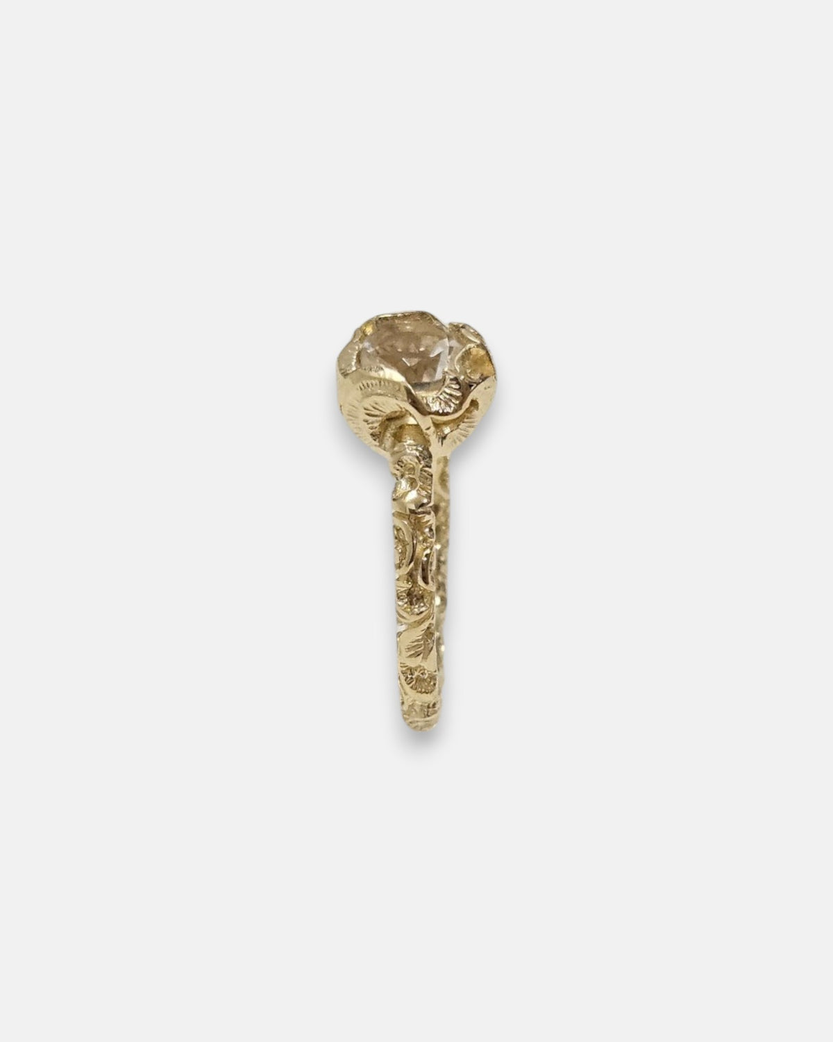 perfil del anillo Ottavia, detallando la elevación de la corona floral chapada en oro y el aro grabado.