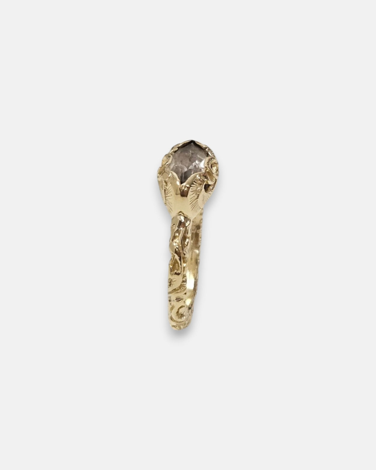 perfil del anillo Beatrice, detallando la elevación del engaste de flor y el grabado del aro.