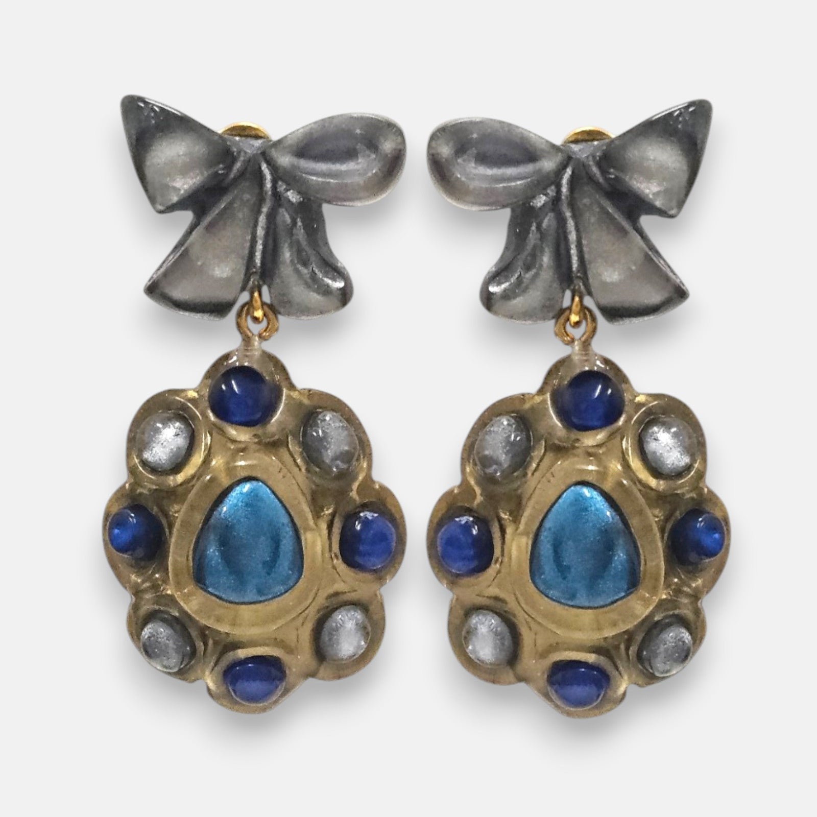 pendientes Colette Bleu de Dominique Denaive en resina artesanal con lazo gris y medallón dorado con cabujones azules.