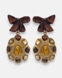 pendientes Colette Ambre de Dominique Denaive en resina artesanal con lazo granate y medallón dorado con cabujones miel.
