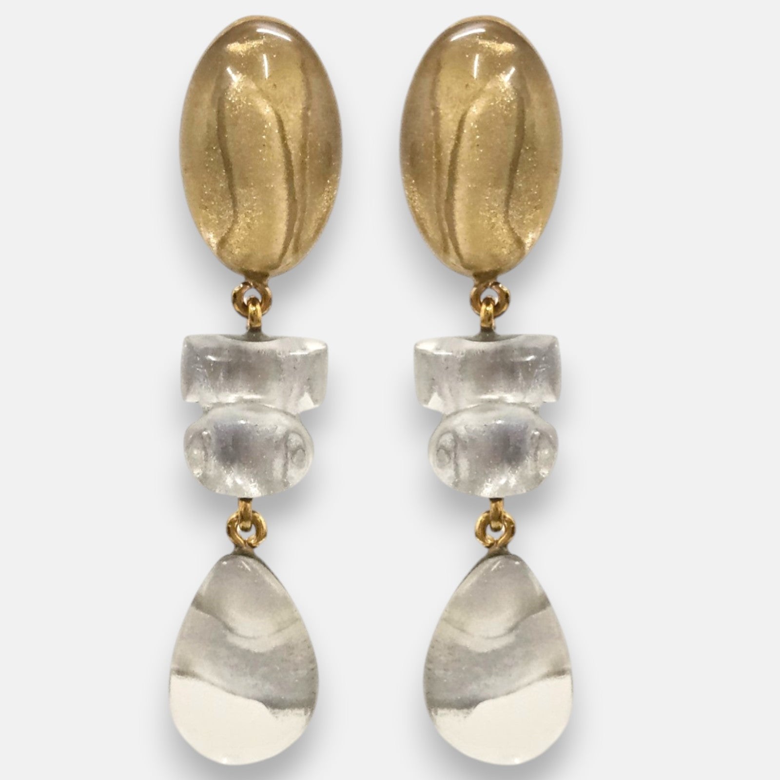 pendientes largos Margot de Dominique Denaive con tres módulos articulados en resina dorada y cristal transparente.