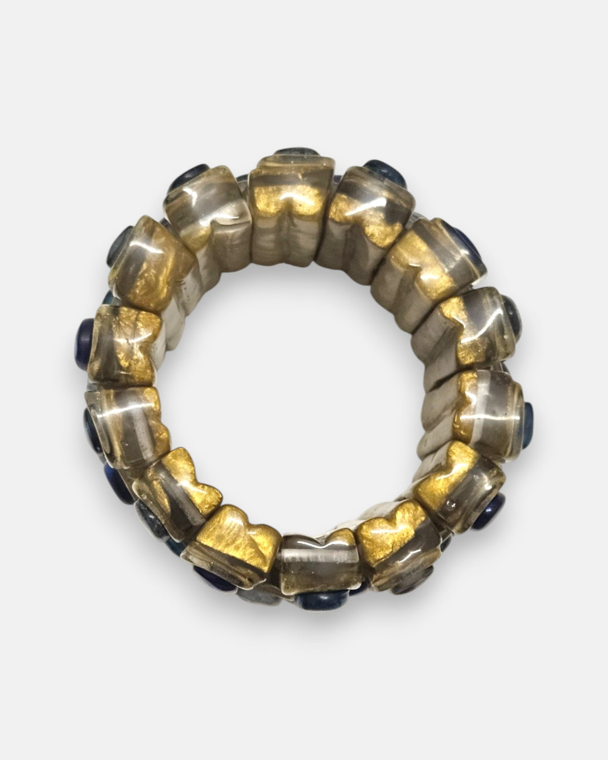 vista circular cenital de la pulsera elástica Océane Bleu, detallando la flexibilidad de sus bloques de resina dorada.