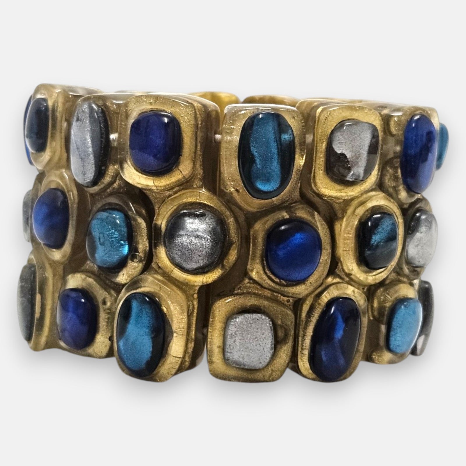pulsera ancha Océane Bleu de Dominique Denaive en resina dorada con tres hileras de cabujones en azul cobalto, turquesa y plata.