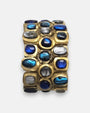 primer plano macro de la pulsera Océane Bleu, permitiendo apreciar los cabujones iridiscentes en azul cobalto, turquesa y plata nacarada sobre la base dorada.