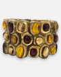 pulsera ancha Miel Garance de Dominique Denaive en resina dorada con tres hileras de cabujones en tonos miel, granate y champán.