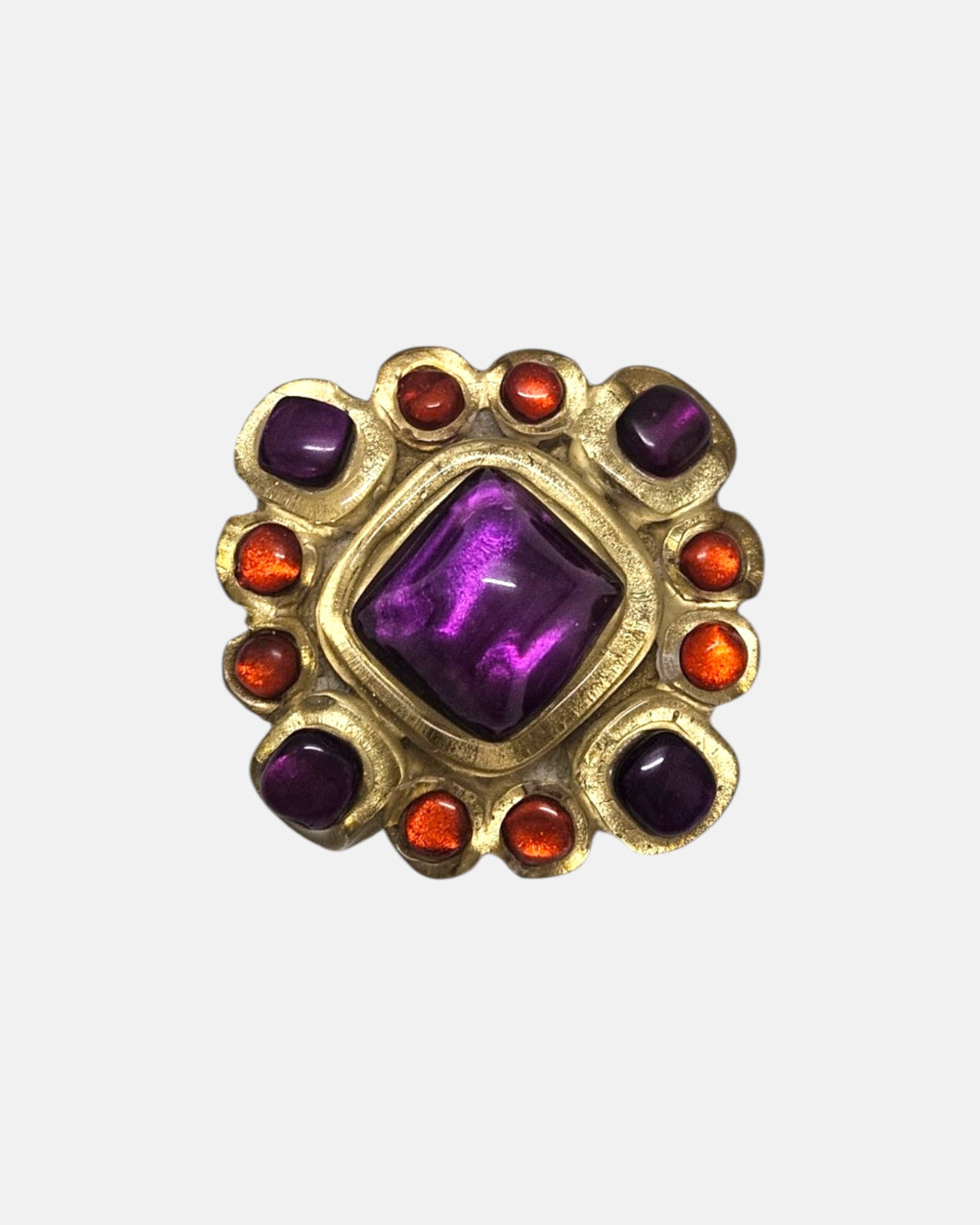 broche de 5x5 cm de Dominique Denaive en resina artesanal dorada con cabujón romboidal violeta y detalles naranjas.