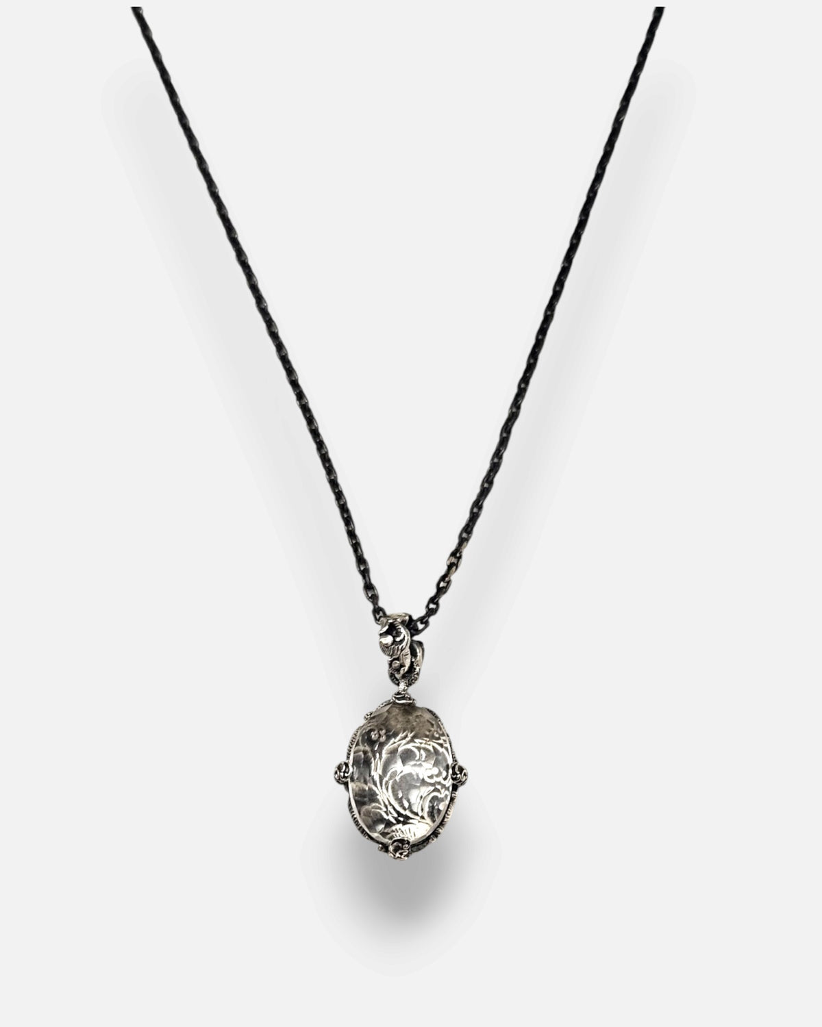 primer plano macro del colgante Médaillon Transparent et Argent Baroque de Maria e Luisa, permitiendo apreciar la talla faceteada del cristal, la reasa ornamentada y las garras de plata envejecida.