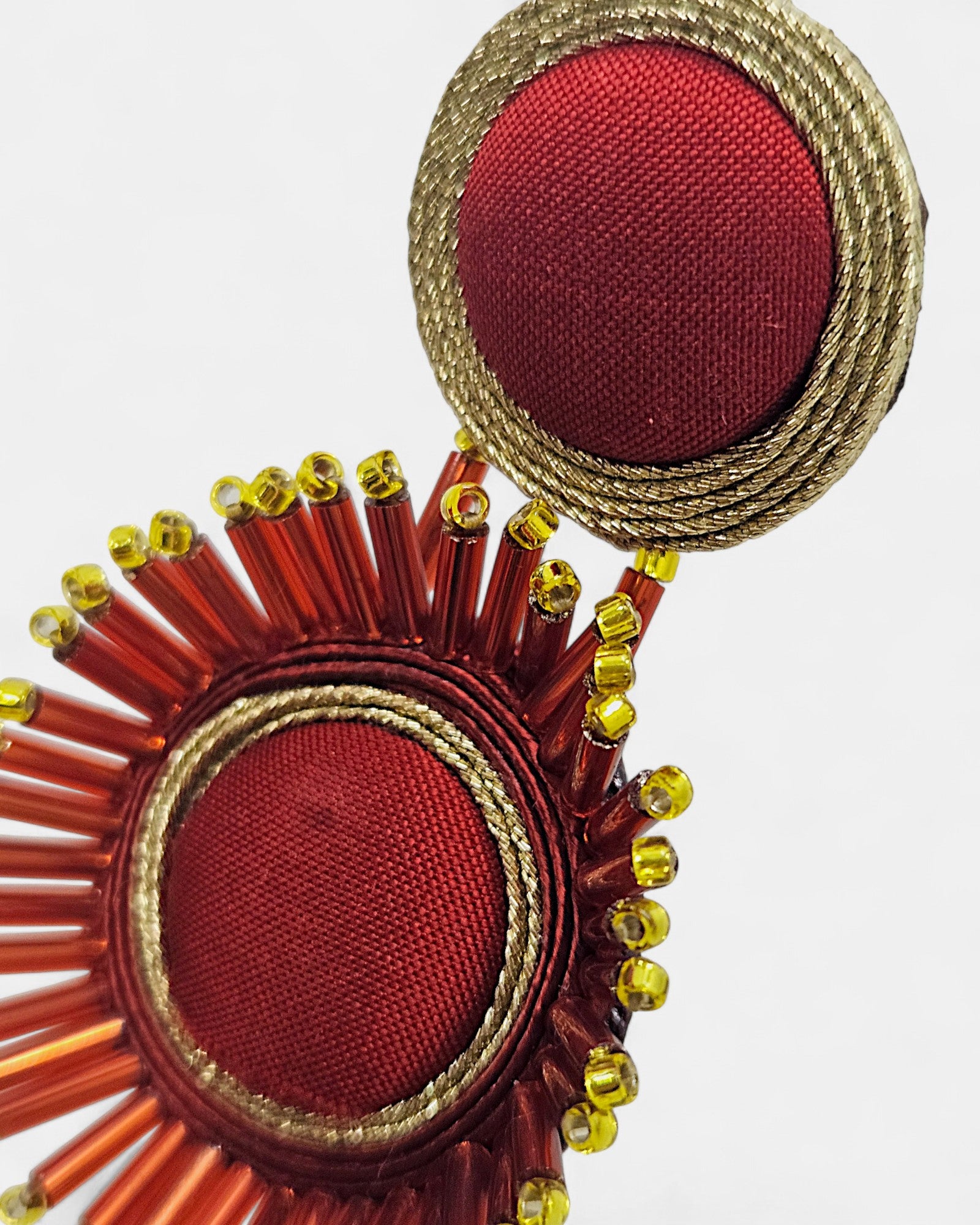 Detalle del bordado de seda carmesí y los canutillos de cristal rojo y dorado de los pendientes Musula.