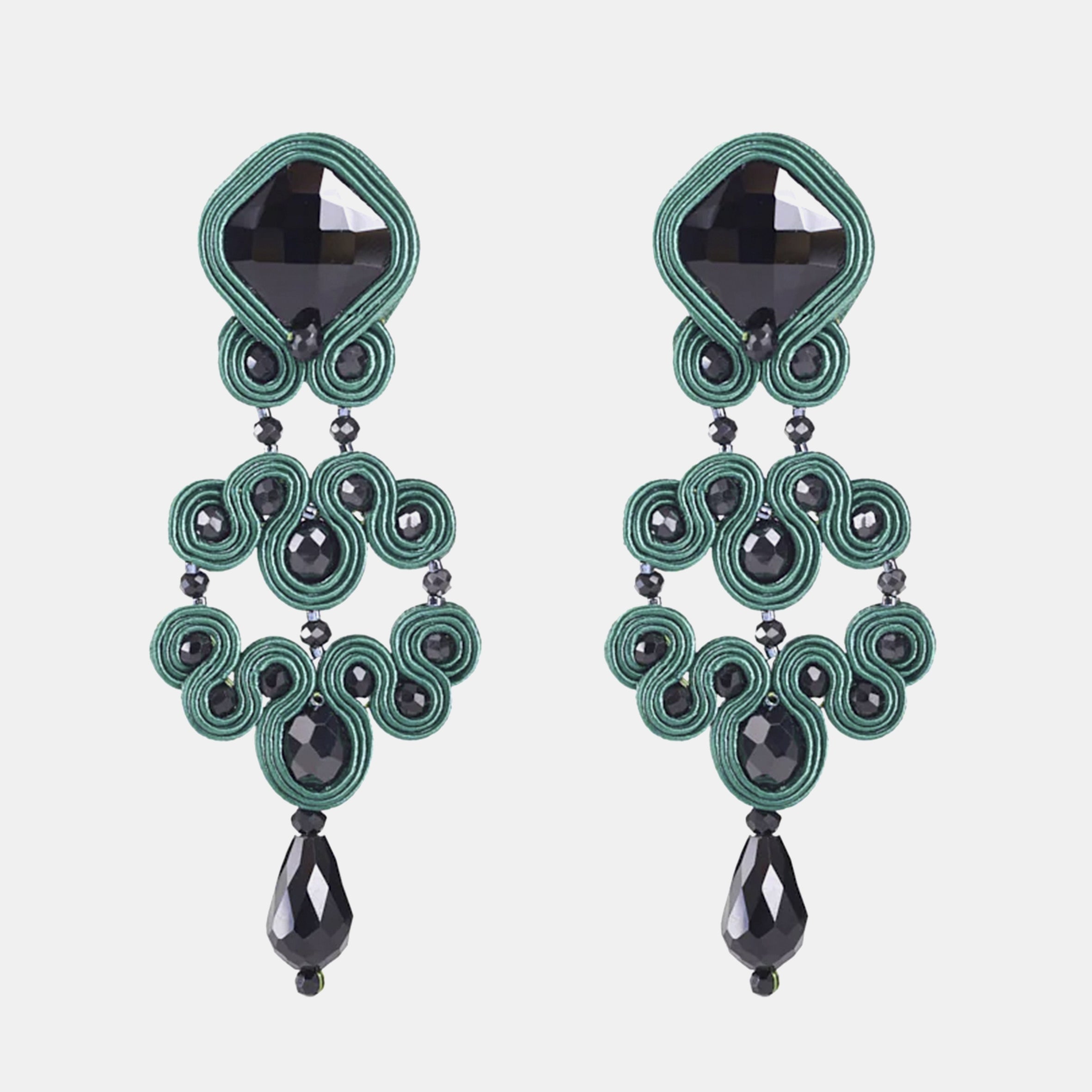 Pareja de pendientes largos Gótico Azabache Verde  con diseño de soutache y cristales negros sobre fondo blanco.