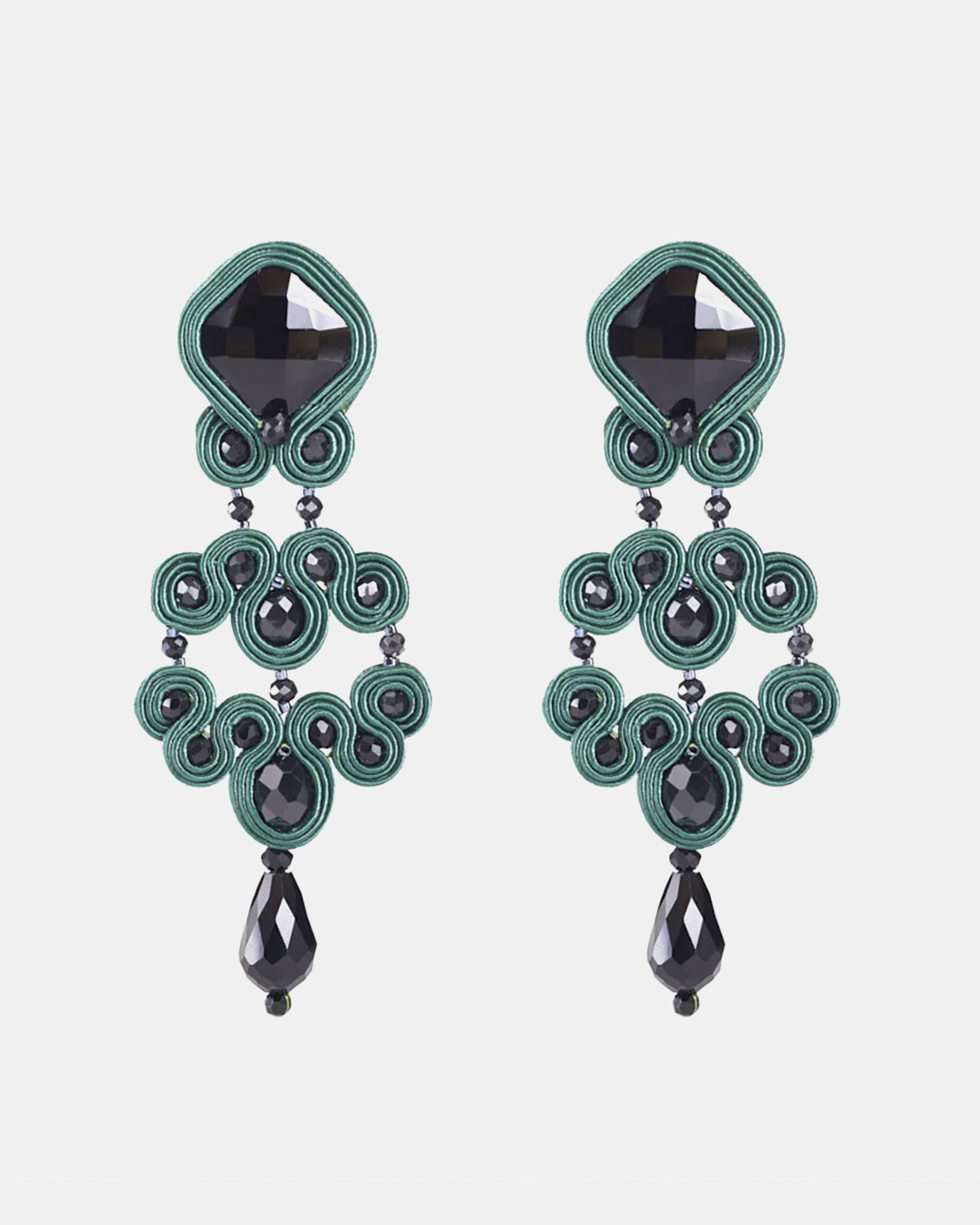Pareja de pendientes largos Gótico Azabache Verde  con diseño de soutache y cristales negros sobre fondo blanco.