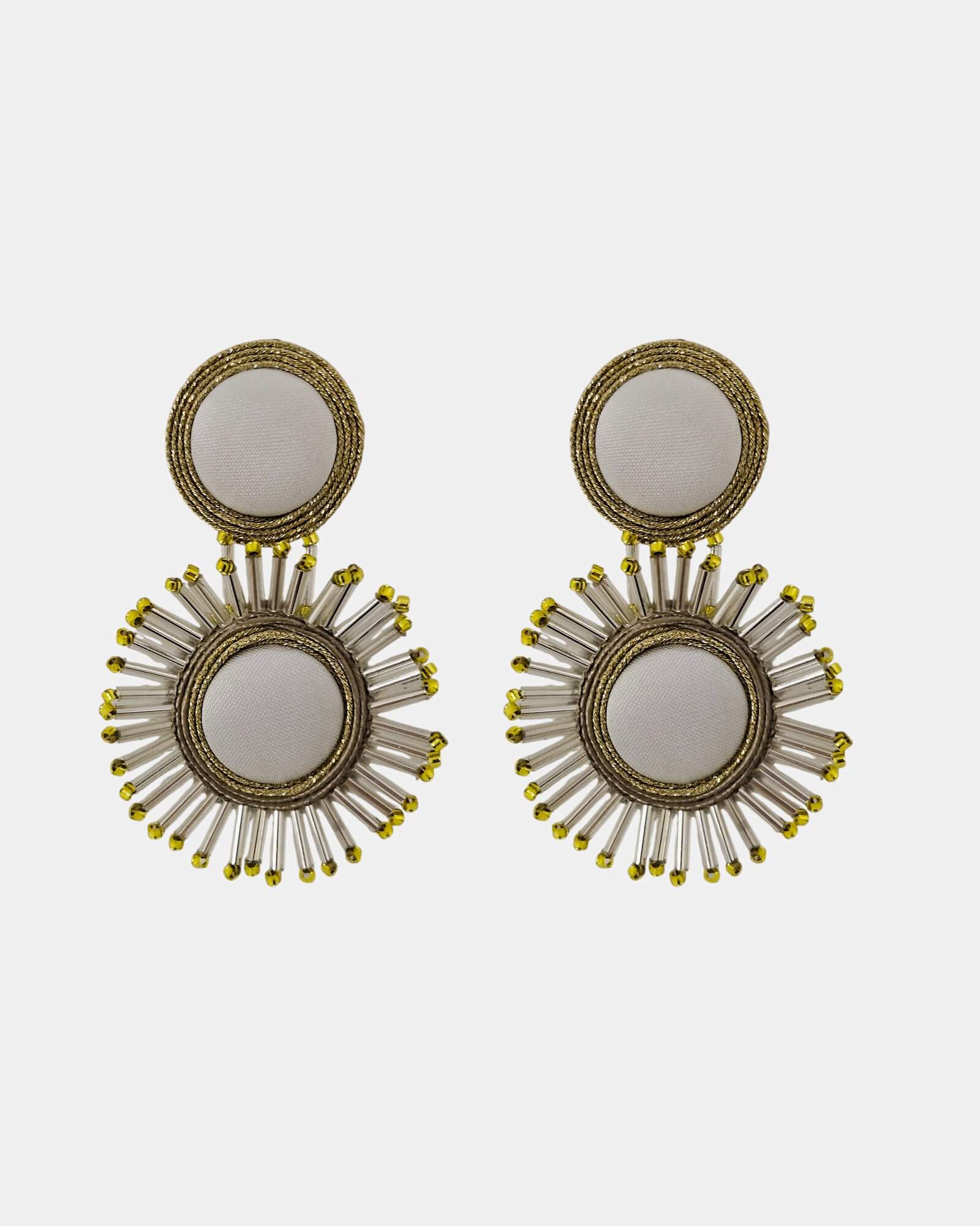 Pareja de pendientes Cretone Ash con diseño radial, seda blanca y cristales sobre fondo blanco.