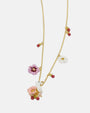 detalle el centro del collar de Les Néréides, destacando la figura del conejito sobre la flor rosa y los charms laterales.