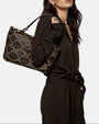 modelo luciendo el bolso Allegra colgado al hombro, apreciando su silueta rectangular y su estilo bohemio chic.