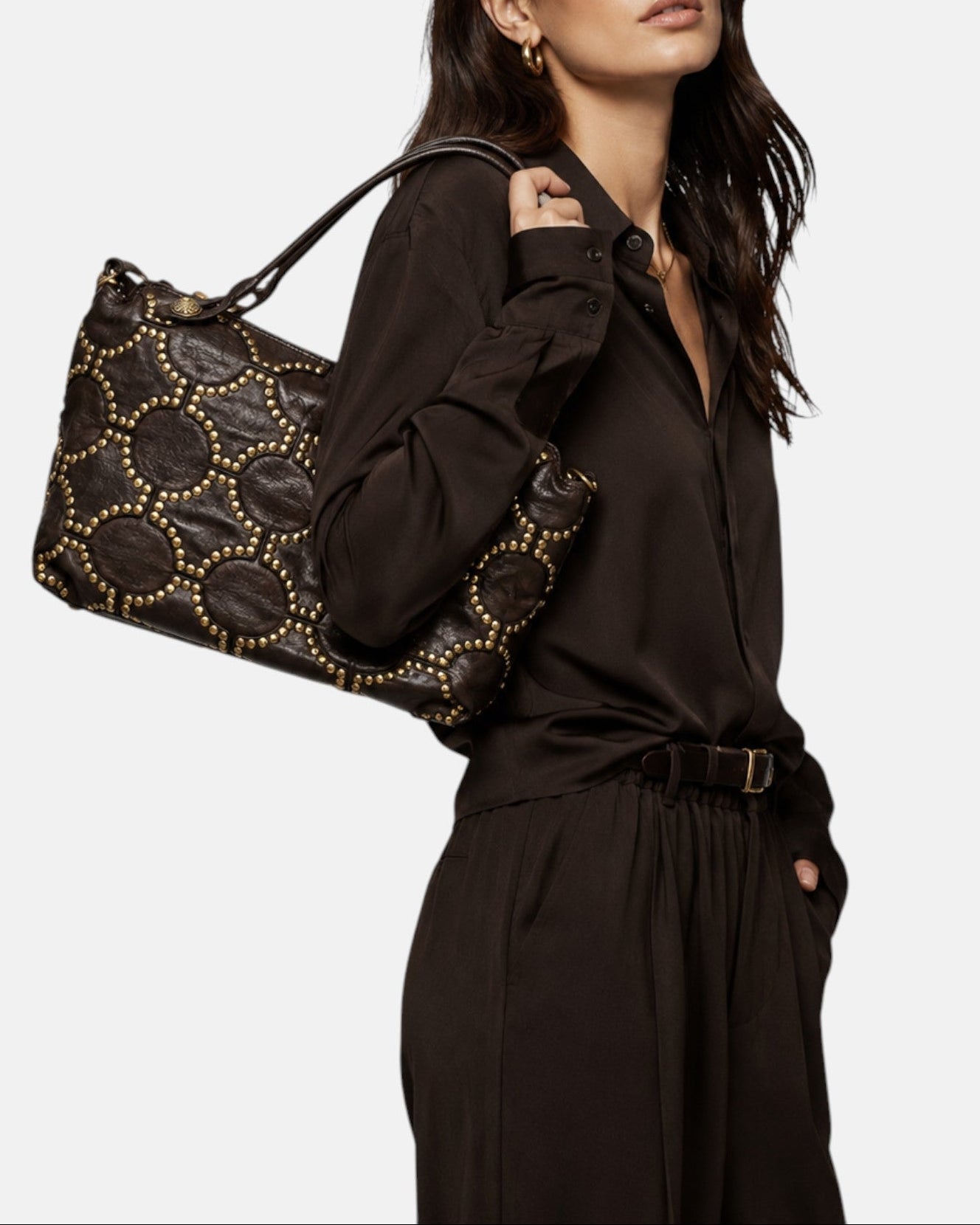 modelo luciendo el bolso Allegra colgado al hombro, apreciando su silueta rectangular y su estilo bohemio chic.