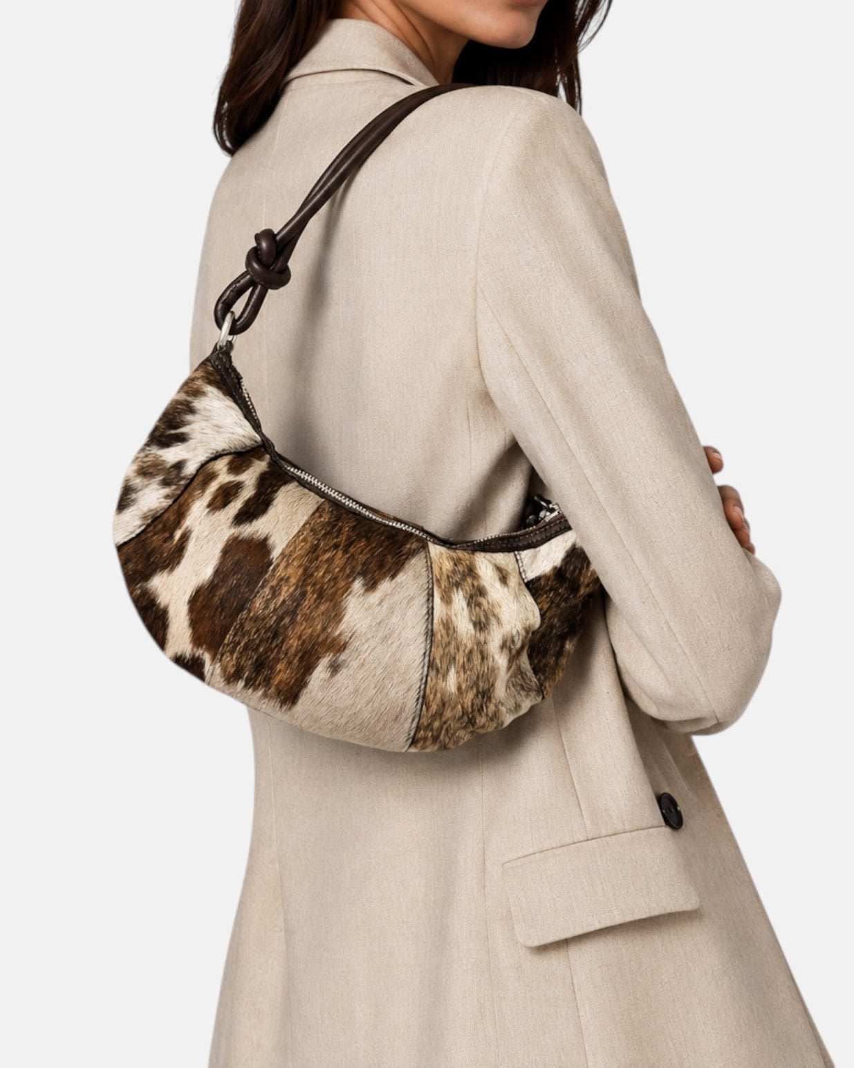 modelo luciendo el bolso Elena colgado al hombro sobre una americana beige, apreciando su escala cómoda y su textura silvestre.