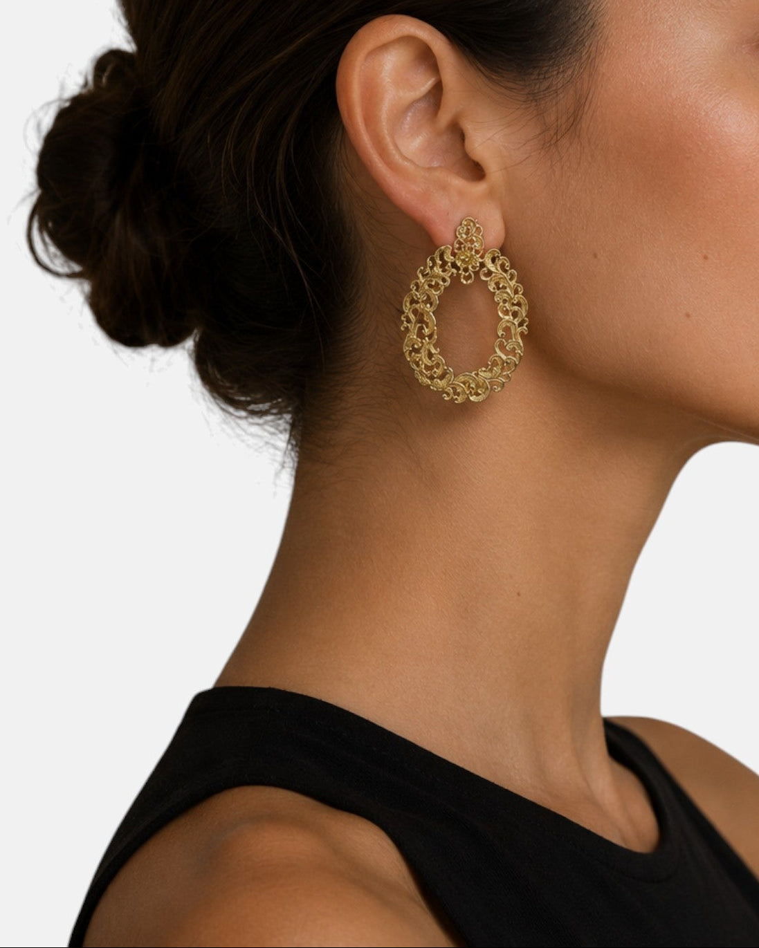 modelo luciendo el pendiente Aurelia, apreciando la calidez del oro y la elegancia del marco ovalado.