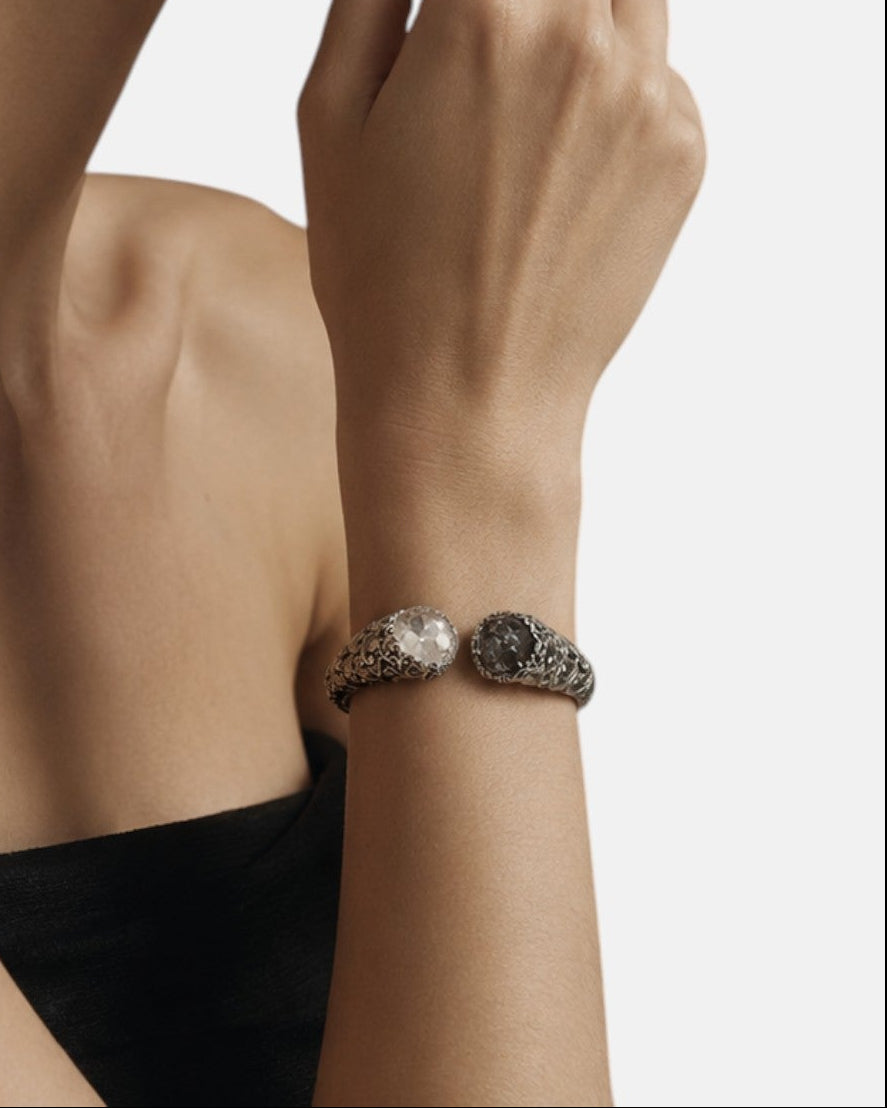 modelo luciendo la pulsera Sibilla en la muñeca, apreciando la escala escultural de la caña y el contraste de sus dos gemas.