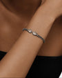 modelo luciendo la pulsera Clarissa en la muñeca, apreciando la elegancia de las dos lágrimas de cristal contrapuestas.
