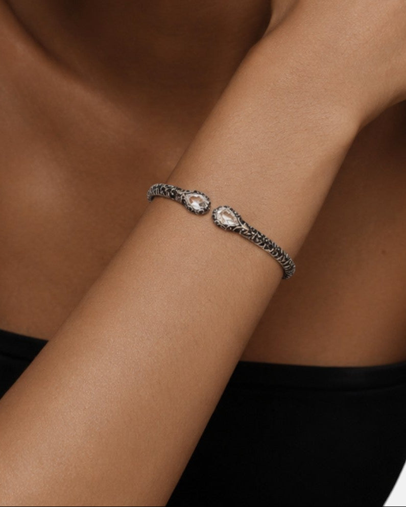 modelo luciendo la pulsera Clarissa en la muñeca, apreciando la elegancia de las dos lágrimas de cristal contrapuestas.