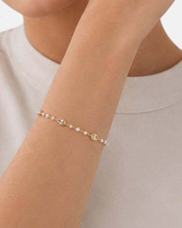 modelo luciendo la pulsera Livia en la muñeca, apreciando la delicadeza de su diseño sobre la piel.