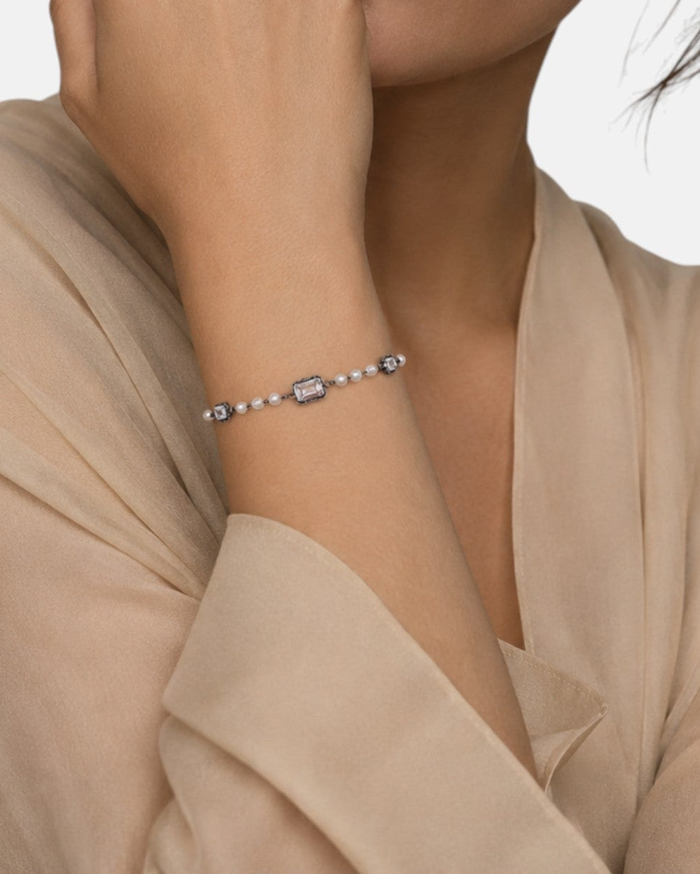 modelo luciendo la pulsera Elettra en la muñeca, apreciando el contraste entre las perlas y la plata oscura.