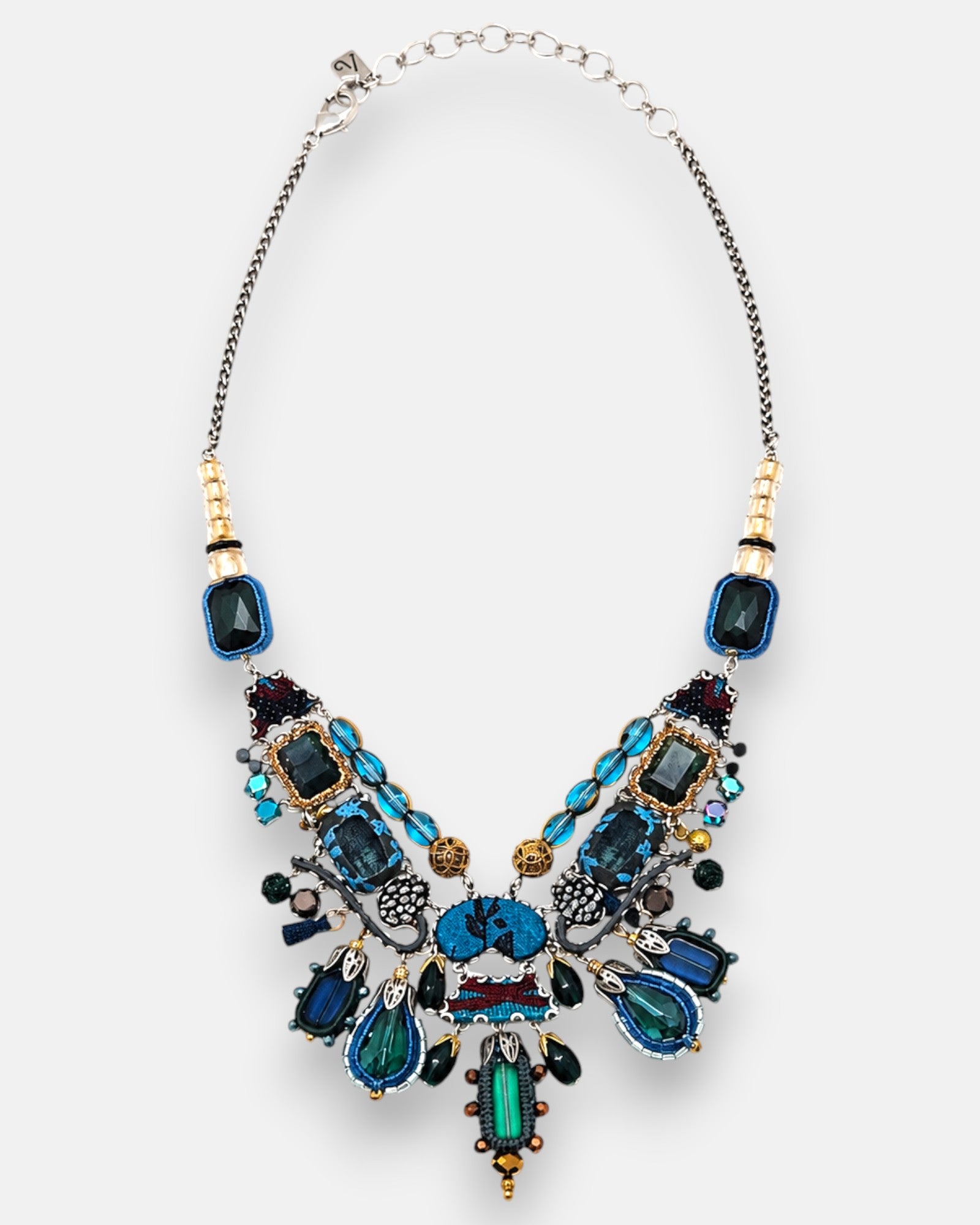 collar colgante en su totalidad, permitiendo observar la disposición del motivo central y el diseño de la cadena metálica envejecida con eslabones regulables.