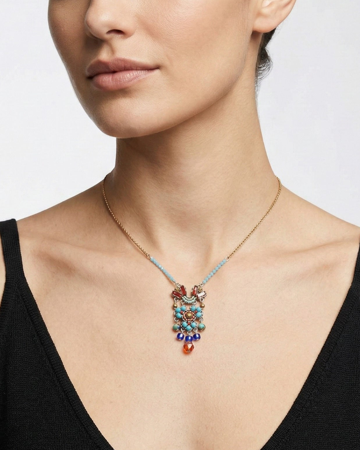 Vista completa del collar Sunlit con su cadena dorada y detalles de cuentas celestes en los laterales.