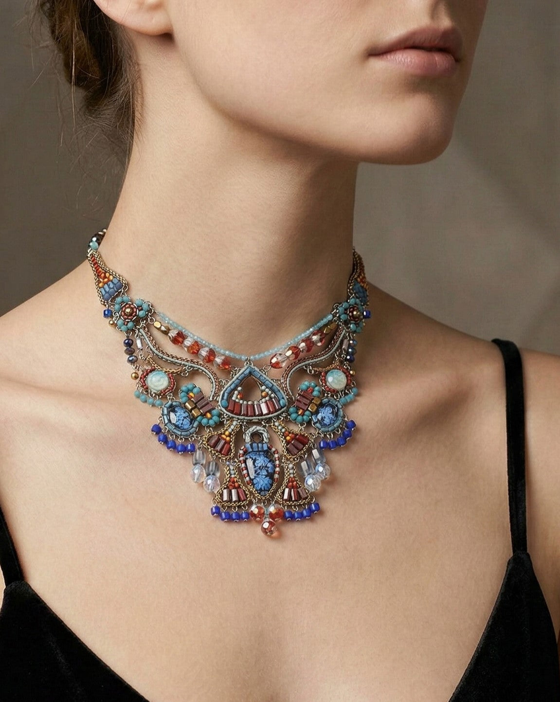 Mujer luciendo el Collar Corto Estival de estilo pechera con cuentas azules y granates.