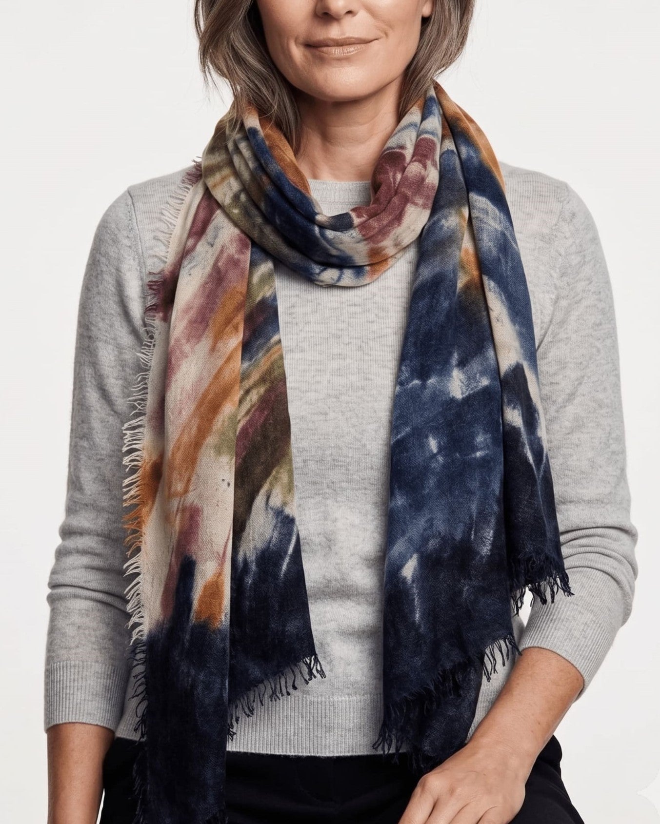 Modelo vistiendo el foulard Faliero Sarti en cashmere tie-dye envuelto al cuello sobre un jersey gris.