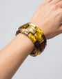 modelo luciendo la pulsera Chain Elastic Ambre en la muñeca, apreciando su volumen geométrico y brillo sobre la piel.