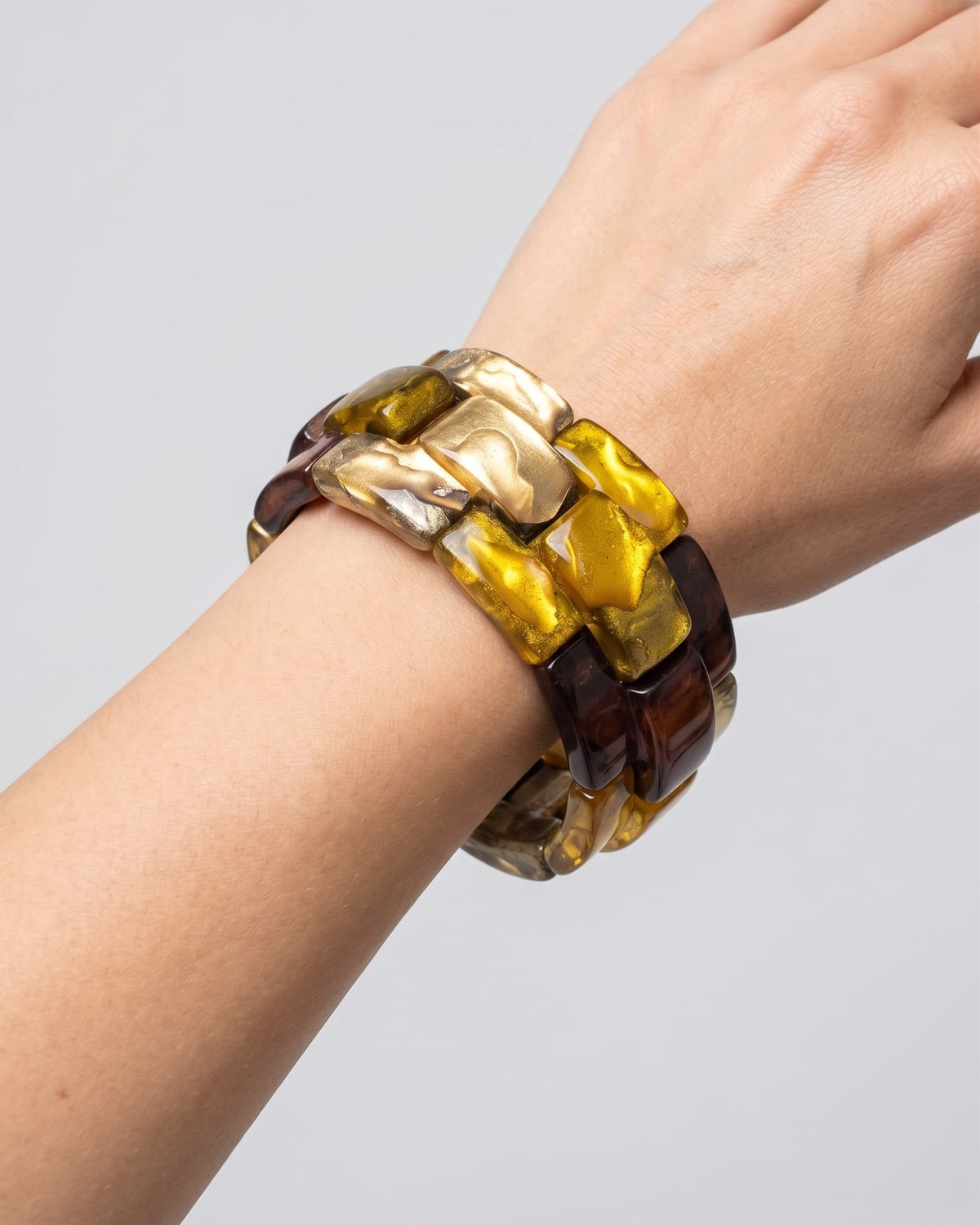 modelo luciendo la pulsera Chain Elastic Ambre en la muñeca, apreciando su volumen geométrico y brillo sobre la piel.