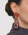 modelo luciendo el pendiente Fleur de Prune en la oreja, apreciando su silueta estilizada y escala sobre la piel.